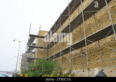 Nicht bearbeitetes Foto zeigt Gerüste für die Erneuerung und Renovierung von alten historischen Gebäuden Burgturmmauern Stockfoto