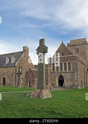 Historisches St. Martin's Cross aus dem 9. Jahrhundert vor der ikonischen, aus Stein erbauten Iona Abbey auf der hebridischen Insel Iona, Schottland, Großbritannien Stockfoto