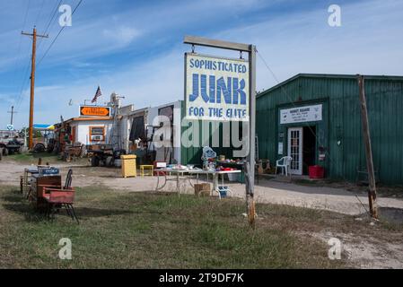 Äußere des Secondhand-Stores mit Schild, das besagt: "Raffinierter Juni für die Elite", Möbel vor der Tür, Leakey, Uvalde County, Texas, Usa. Stockfoto