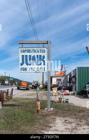 Äußere des Secondhand-Stores mit Schild, das besagt: "Raffinierter Juni für die Elite", Möbel vor der Tür, Leakey, Uvalde County, Texas, Usa. Stockfoto