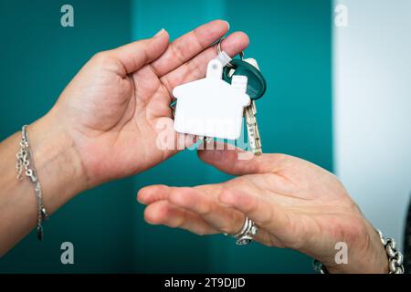 Zwei Hände wechseln die Schlüssel, nachdem sie Immobilien gekauft haben Stockfoto