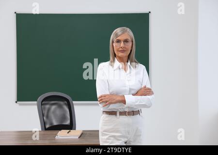 Porträt eines Professors in der Nähe der Tafel im Klassenzimmer, Raum für Text Stockfoto