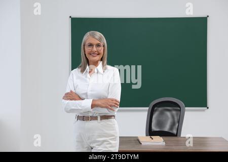 Porträt eines Professors in der Nähe der Tafel im Klassenzimmer, Raum für Text Stockfoto