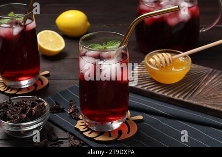 Erfrischender Hibiskustee mit Eiswürfeln und Minze im Glas auf dem Tisch Stockfoto