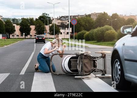 Entsetzliche Mutter auf dem Weg nach einem Autounfall, als ein Fahrzeug ihren Kinderwagen trifft. Konzepte von Sicherheit, Verkehrsordnung und Versicherung. Stockfoto