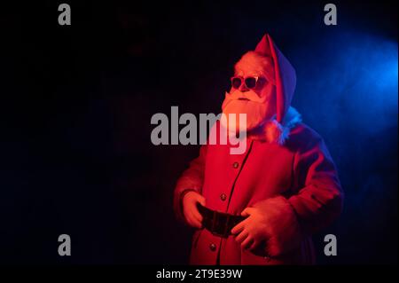 Porträt des Weihnachtsmannes in Sonnenbrille im Neonlicht. Stockfoto