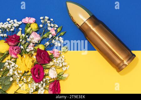 Pazifismus und Gewaltlosigkeit. Große Kugel und ein Haufen verschiedener Blumen und ukrainische Flagge. Stockfoto