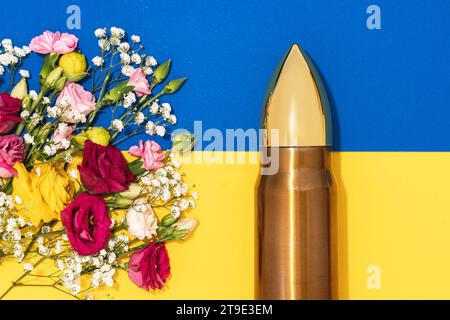 Pazifismus und Gewaltlosigkeit. Große Kugel und ein Haufen verschiedener Blumen und ukrainische Flagge. Stockfoto