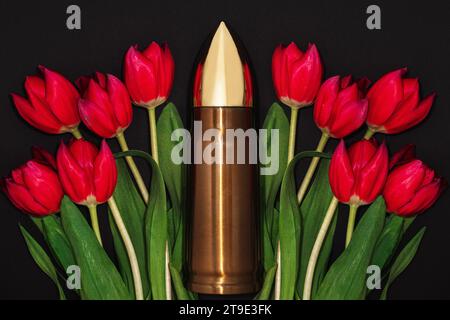 Pazifismus, Gewaltfreiheit oder Siegestag. Große Kugel und ein Haufen roter Tulpen. Stockfoto