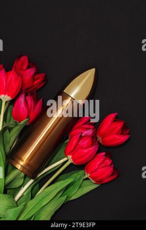 Pazifismus, Gewaltfreiheit oder Siegestag. Große Kugel und ein Haufen roter Tulpen. Stockfoto