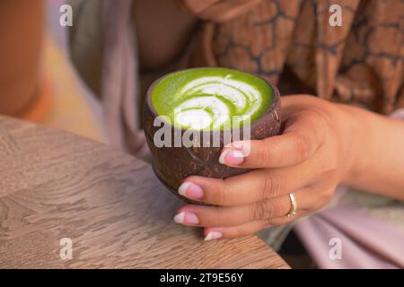 matcha Latte in einer Tasse in Kokosform Stockfoto