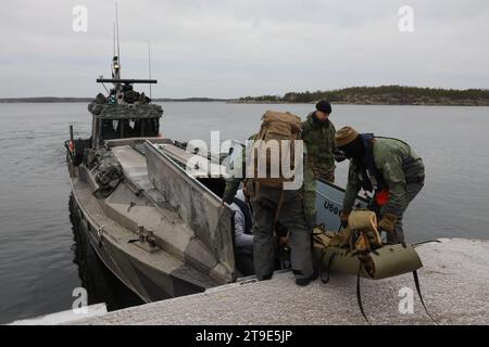 US-Marines und US-Navy-Seeleute mit 2. Aufklärungsbataillon, 2. Marinedivision und Combat Logistics Battalion 6, Combat Logistics Regiment 2, 2. Marine Logistics Group, transportieren einen simulierten Unfall auf ein finnisches Landungsschiff der Jehu-600-Klasse während einer Evakuierungsübung in Hästö Busö, Finnland, am 18. November 2023. Die Übung unterstreicht die Bereitschaft von CLB-6, taktische Evakuierungsoperationen in extremer Kälte durchzuführen, skalierbare, agile und reaktionsschnelle anschraubbare Schadenskontrolle Reanimation und Role I medizinische Unterstützung in anspruchsvollen Szenarien zu bieten, RUF Stockfoto