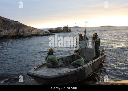 US-Marines und US-Navy-Seeleute mit 2. Aufklärungsbataillon, 2. Marine-Division und Combat Logistics Battalion 6, Combat Logistics Regiment 2, 2. Marine Logistics Group, warten auf einen medizinischen Anruf in einem finnischen Landeboot der G-Klasse während einer Evakuierungsübung in Hästö Busö, Finnland, am 18. November 2023. Die Übung unterstreicht die Bereitschaft des CLB-6, taktische Evakuierungsoperationen in extremer Kälte durchzuführen, skalierbare, agile und reaktionsschnelle Anschraubungs-Schadensbegrenzung für Wiederbelebung und medizinische Unterstützung der Rolle I in anspruchsvollen Szenarien zu bieten und so seine RO zu verstärken Stockfoto