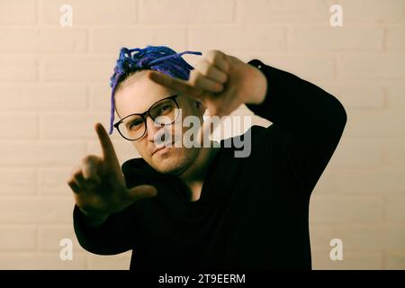 Der lebendige Mann mit auffälligen lila Dreadlocks und einzigartigem Stil. Stockfoto