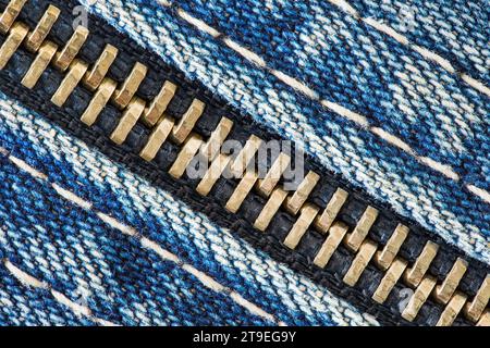 Reißverschluss mit Metallzähnen auf Denim-Gewebe, Nahaufnahme Makroansicht Stockfoto