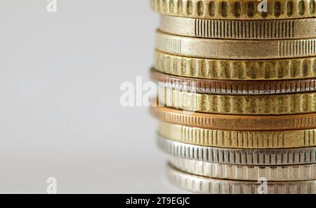 Alte Münzen aus weißen und gelben Metallen, gestapelt im Stapel, Seitenansicht der Rippen, Nahaufnahme Makro Stockfoto