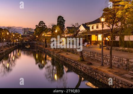 Kurashiki Bikan Historisches Viertel in der Abenddämmerung. Stadtbild bekannt für typisch japanische weiße Wohnwände und Weidenbäume am Ufer Stockfoto