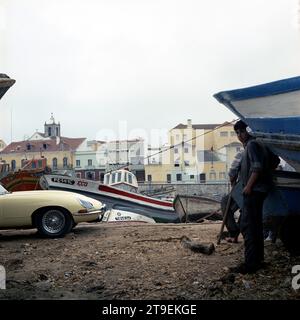 1966 Cream Jaguar E-TYPE, Serie 1, 2+2, im portugiesischen Hafen mit Fischerbooten Stockfoto