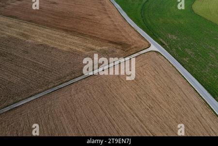 Drohnenansicht einer Landstraße zwischen ernteten und grünen Feldern, Innviertel, Oberösterreich, Österreich Stockfoto