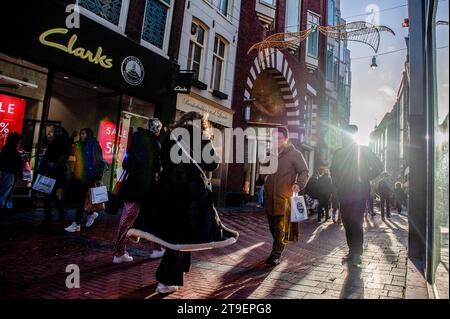 Amsterdam, Niederlande. November 2023. Man sieht Menschen, die auf den Straßen laufen, während sie Einkaufstaschen tragen. In Amsterdam sind die Geschäfte mit Black Friday-Angeboten fertig, und die Schaufenster sind mit Werbebanner verziert, um während des Black Friday Menschen anzulocken. Vor allem jüngere Menschen warten auf den Ermäßigungstag nach Amerikas Thanksgiving, um Dinge zu kaufen. (Foto: Ana Fernandez/SOPA Images/SIPA USA) Credit: SIPA USA/Alamy Live News Stockfoto