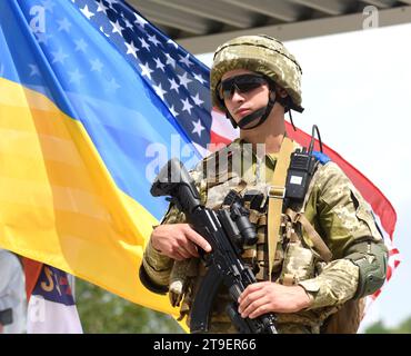 Javoriv, Ukraine - 27. Juli 2021. Ukrainischer Soldat in der Nähe der Flaggen der Ukraine und der USA während der multinationalen Militärübung der drei Schwerter 2021 in der Nähe von Ya Stockfoto