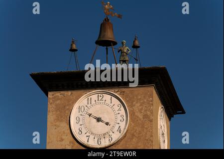 Auf dem mittelalterlichen Maurizio-Turm (Torre di Maurizio) auf der Piazza del Duomo in Orvieto, Umbrien, Italien, trifft eine automatische Bronzestuppe die Stunden. Diese 1348 fertiggestellte mechanische Uhr war die erste dieser Art, die in Europa dokumentiert wurde. Sie wurde von der Opera del Duomo (Werkstatt der Kathedrale von Orvieto) beauftragt, die Arbeiter auf der Baustelle der Kathedrale zu kontrollieren. Der ursprüngliche Name der Uhr war „ariologium de muriccio“, d. h. Baustellenuhr. Der bronzene Glockenschlag zeigt einen Offizier der Opera del Duomo, einen Dottiere. Stockfoto