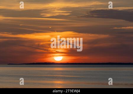 Ein farbenfroher Sonnenuntergang reflektiert sich auf einem ruhigen und ruhigen Bristol Kanal Stockfoto