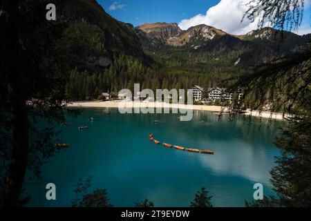 Pragser Wildsee, atemberaubender Alpensee mit schöner blauer Farbe, Berggipfel im Hintergrund. Reihe typischer Holzboote. Stockfoto