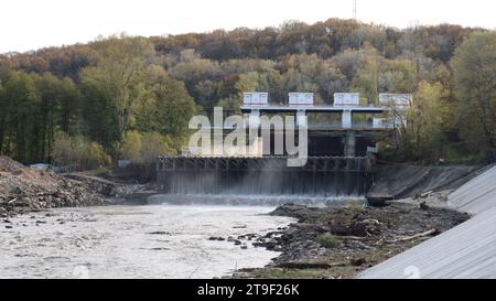 Stadtdamm in der Republik Adygea, während der Zeit der Wasserabgabe, Parklandschaft mit einem Damm, der einen mächtigen Wasserstrom in den Fluss freigibt Stockfoto