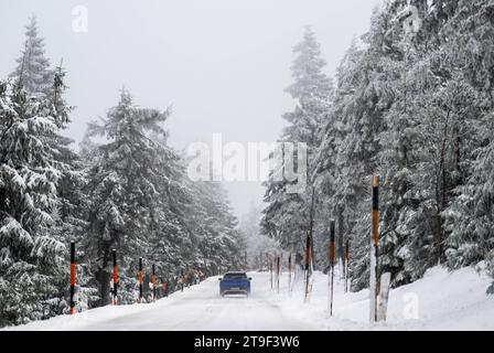 Oberwiesenthal, Deutschland. November 2023. Ein Auto fährt durch die schneebedeckte Landschaft. In der Nacht gab es Neuschnee im Erzgebirge. Kristin Schmidt/dpa/Alamy Live News Stockfoto