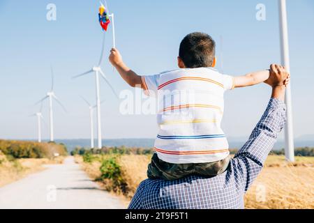 Vater hält Tochter mit Windrad Stockfoto