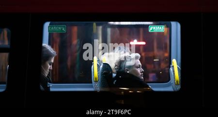 Belgrad, Serbien, 23. November 2023: Weibliche Passagiere sitzen auf Fenstersitzen, während sie in einem Stadtbus in der Nacht fahren Stockfoto