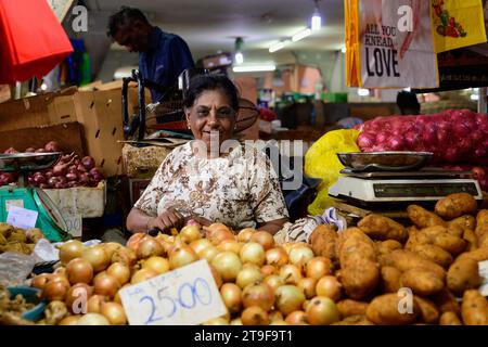 Port Louis, Mauritius - 25. Oktober 2023: Gemüsehändler verkauft Zwiebeln auf dem zentralen Markt von Port Louis Stockfoto