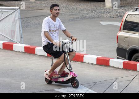 SAMUT PRAKAN, THAILAND, 03. November 2023, Ein junger Mann fährt einen Elektroroller Stockfoto