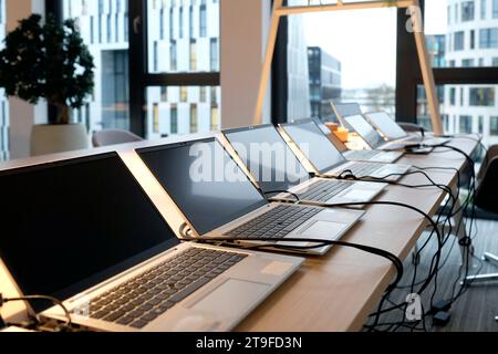 Reihe von Laptops, die für neue Mitarbeiter in einem Unternehmen vorbereitet und eingerichtet werden Stockfoto