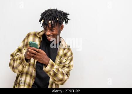 Porträt eines fröhlichen, jungen Schwarzen, der eine Nachricht per Handy sendet. Glücklicher afroamerikanischer Mann mit Smartphone, der gerne online chattet, Nachrichten schickt Stockfoto