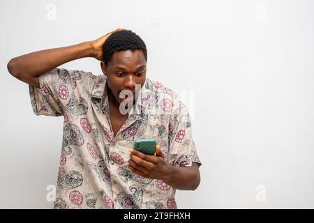 Porträt eines fröhlichen, jungen Schwarzen, der eine Nachricht per Handy sendet. Glücklicher afroamerikanischer Mann mit Smartphone, der gerne online chattet, Nachrichten schickt Stockfoto