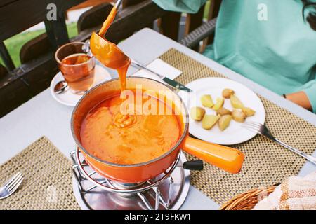 Tomatenfondue ist im Wallis beheimatet und besteht aus Tomaten oder Tomatenpaste, traditioneller schweizer Platte Stockfoto