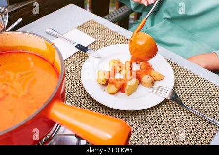 Tomatenfondue ist im Wallis beheimatet und besteht aus Tomaten oder Tomatenpaste, traditioneller schweizer Platte Stockfoto