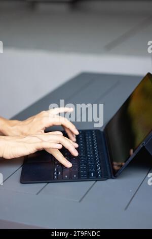 Nahaufnahme einer Frau Hände auf der Tastatur des Laptops im dunklen Raum, Leute, die zu Hause arbeiten, modernes schwarzes Notebook. Internet, Arbeit, Technologiekonzept. Stockfoto