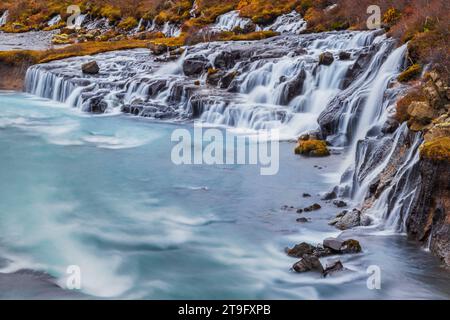 Der Hraunfossar-Wasserfall im Herbst ist eine Reihe von Wasserfällen, die von Rinneimen gebildet werden, die sich über eine Entfernung von etwa 900 Metern in Island erstrecken, ein absolutes muss. Stockfoto