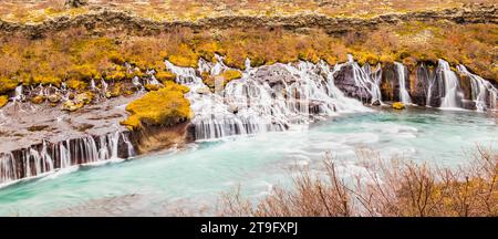 Der Hraunfossar-Wasserfall im Herbst ist eine Reihe von Wasserfällen, die von Rinneimen gebildet werden, die sich über eine Entfernung von etwa 900 Metern in Island erstrecken, ein absolutes muss. Stockfoto