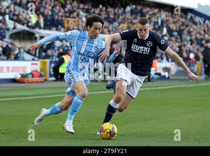 Tatsuhiro Sakamoto von Coventry City (links) und Murray Wallace von Millwall kämpfen um den Ball während des Sky Bet Championship Matches im den, London. Bilddatum: Samstag, 25. November 2023. Stockfoto