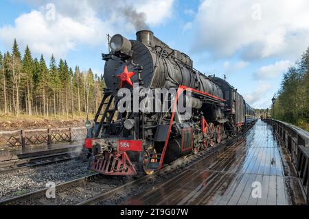 RUSKEALA, RUSSLAND - 06. OKTOBER 2023: Die alte sowjetische Dampflokomotive L-5164 mit dem touristischen Retro-Zug „Ruskeala Express“ auf dem Bahnsteig der Ruskeal Stockfoto