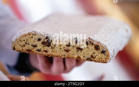 Dorfchemnitz, Deutschland. November 2023. Ein 40 Meter langer Weihnachtsstollen wird beim 1. Sächsischen Stollenfest im Walderlebnisdorf Blockhausen geschnitten. Der Stollen bestand aus Einzelstücken, die 25 Bäckereien aus drei Zünften (Erzgebirge, Vogtland und Meißen) beisteuerten. Die Stollenstücke wurden für einen guten Zweck verkauft. Kristin Schmidt/dpa/Alamy Live News Stockfoto