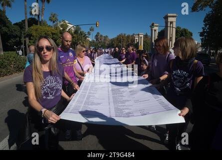 Malaga, Spanien. November 2023. Demonstranten werden bei einer Demonstration des Internationalen Tages zur Beseitigung der Gewalt gegen Frauen mit einem großen Banner mit den Namen der Frauen gesehen, die von ihren Partnern getötet wurden. Dutzende Demonstranten gehen auf die Straßen von Malaga, um die Frauenmorde und -Mißbraucher in einer landesweiten Bewegung zu verurteilen, die jeden 25. November stattfindet. Quelle: SOPA Images Limited/Alamy Live News Stockfoto