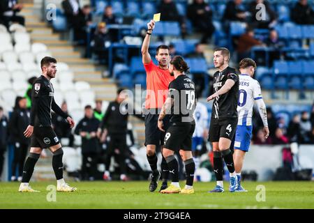 Barrow’s Dom Telford erhält eine gelbe Karte vom Schiedsrichter Declan Bourne während des Spiels der Sky Bet League Two im JobServe Community Stadium in Colchester. Bilddatum: Samstag, 25. November 2023. Stockfoto