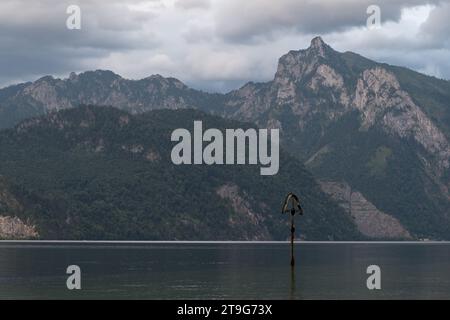 Ein Gedenkkreuz an der Stelle des Schiffsunglücks erinnert an das Schiffswrack von 1910 und den Traunstein, 1691 m über dem Meeresspiegel über Traunse Stockfoto