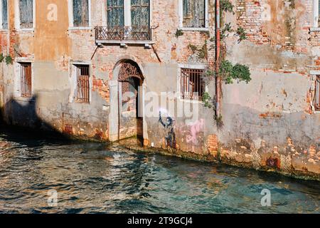 Venedig, Italien - 9. November 2023: Venedig Kanalgewässer, Tor und Graffiti von Banksy, dem Schiffbrüchigen Migrantenkinder Stencil Street Art Stockfoto