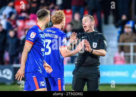 Die Spieler des FC Milton Keynes Dons streiten mit dem Schiedsrichter Scott Jackson, nachdem er am Samstag, den 25. November 2023, im Peninsula Stadium, Moor Lane, in Salford den Elfmeterschieß während des Spiels der Sky Bet League 2 zwischen Salford City und MK Dons vergeben hatte. (Foto: Ian Charles | MI News) Credit: MI News & Sport /Alamy Live News Stockfoto